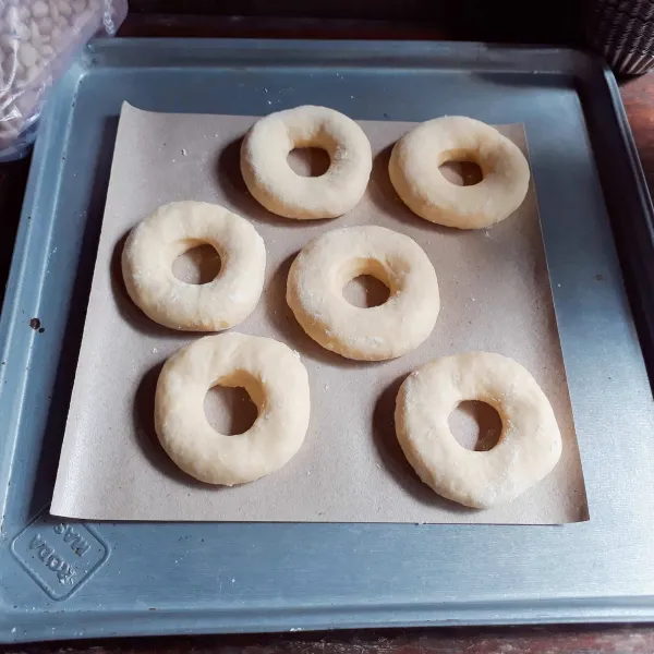 Kempiskan adonan, cetak - cetak bentuk bulat dan lubangi tengahnya. Diamkan donut selama 10 menit.