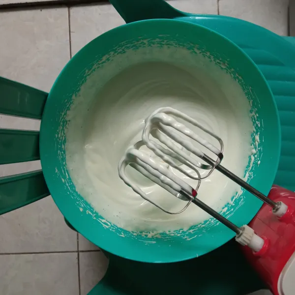 Mixer dengan kecepatan tinggi hingga mengembang, lalu kental dan putih berjejak.