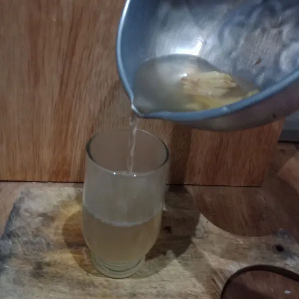 Kemudian tuang air jahe ke dalam gelas, aduk sampai gula larut.