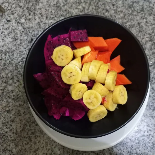 Siapkan potongan buah pepaya, buah naga dan pisang tuang pada mangkuk