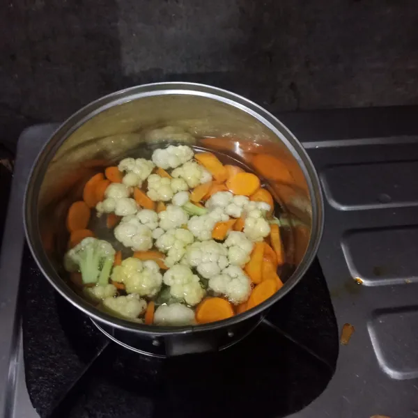 Panaskan air dalam panci, lalu rebus  wortel dan bungkul sampai setengah empuk, kemudian tiriskan.