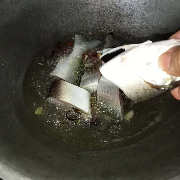 Tuang air dan setelah mendidih, masukkan ikan bandeng.