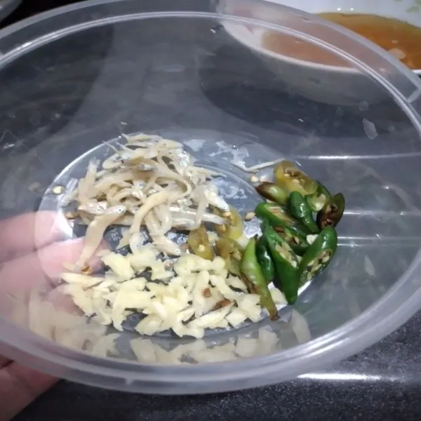 Iris cabe merah, cincang atau iris bawang putih, rendam ikan teri dengan air panas selama 3 menit, tiriskan.