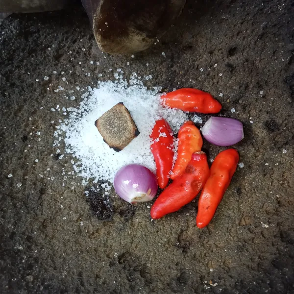 Yaruh cabai rawit, terasi, bawang merah, garam, gula pasir dan kaldu jamur di cobek.