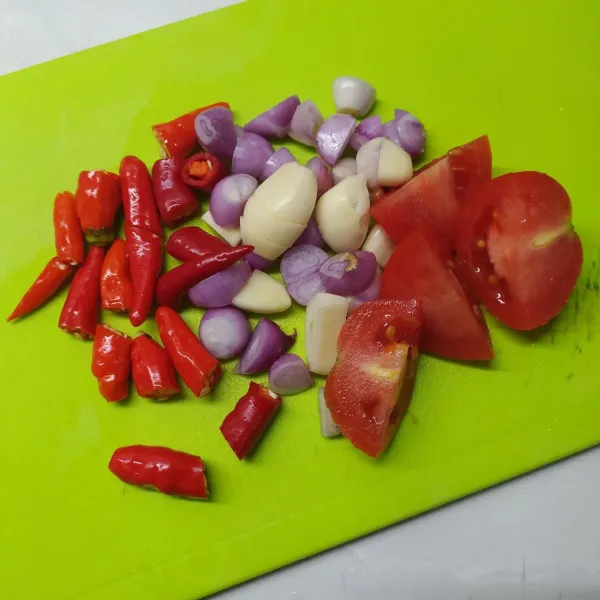 Siapkan bahan sambal, iris bawang putih, bawang merah, iris tomat, potong cabe merah dan cabe rawit (agar tidak meletus saat digoreng).