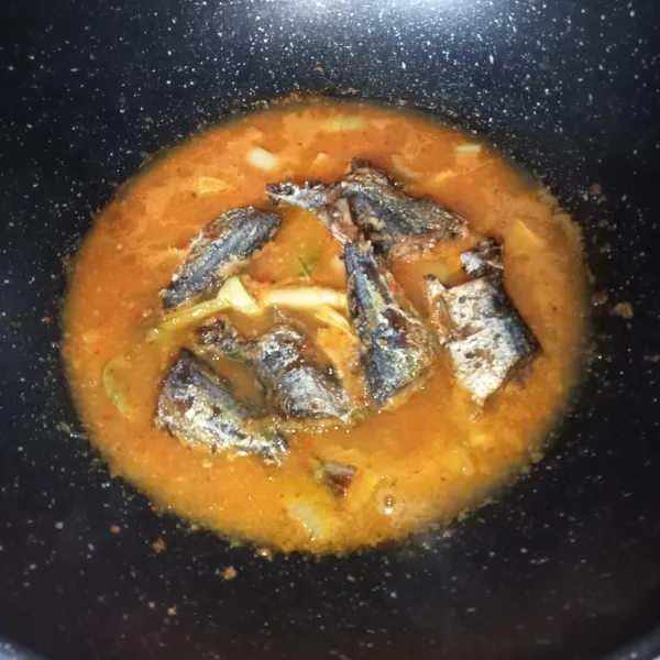 Tuang air dan setelah mendidih, masukkan ikan sarden goreng.