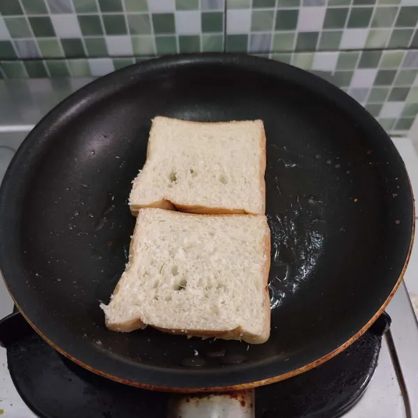Panggang roti tawar hingga setengah matang, kemudian dibalik.