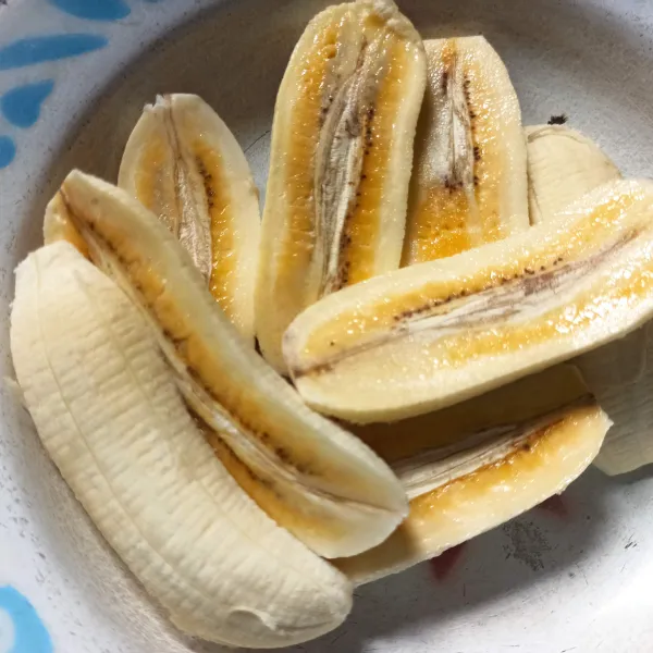 Kupas pisang, kemudian belah menjadi 2 bagian.