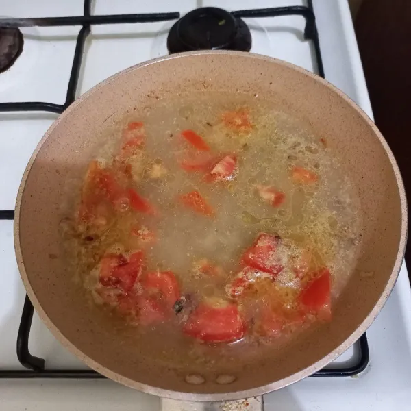 Tambahkan air dan irisan tomat.