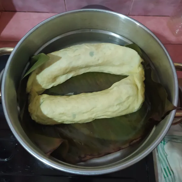 Alasi kukusan dengan daun pisang yang diolesi minyak. Letakkan eggroll lalu kukus selama 20 menit.
