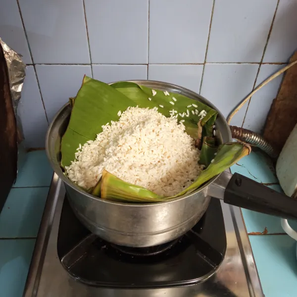Masukkan beras ketan dan satu lembar daun pandan ke dalam panci pengukus yang telah di alasi daun pisang, lalu kukus selama 15 menit.