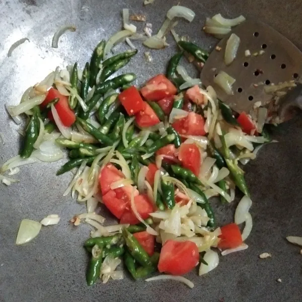Masukkan tomat dan cabe keriting hijau juga bumbu lainnya, tumis hingga bumbu matang.