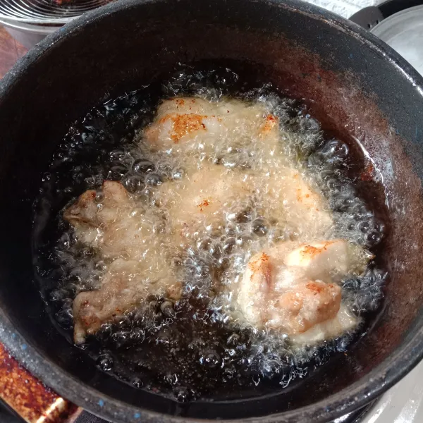 Goreng ayam dalam minyak panas dengan api sedang sampai matang dan kecokelatan.