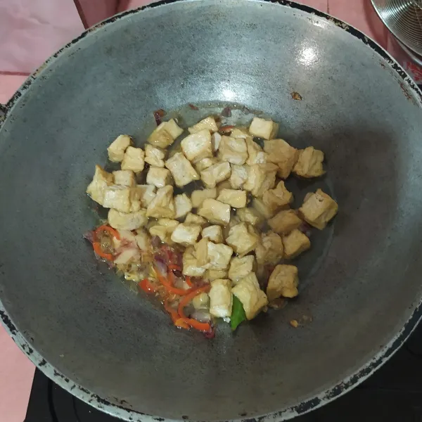 Tuang air, masukkan tahu goreng.