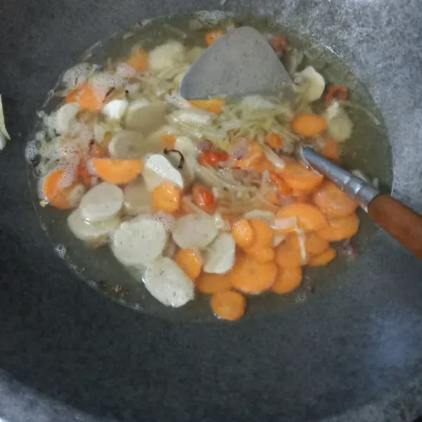 Tuang air, biarkan mendidih. Masukkan wortel dan baso, masak hingga wortel setengah matang.