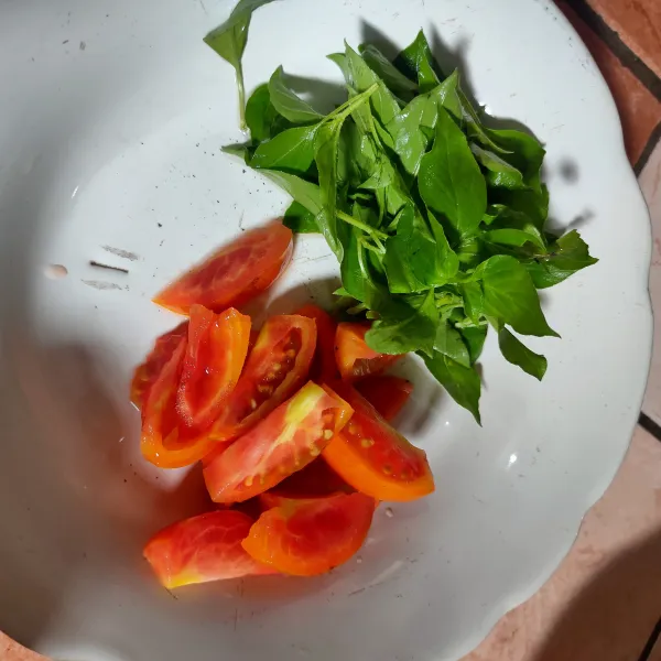 Bersihkan daun kemangi, potong-potong tomat lalu sisihkan.
