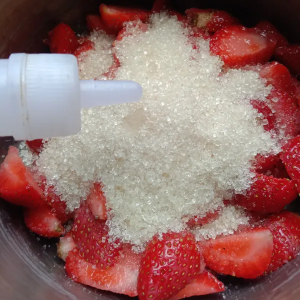 Dalam sebuah panci, masukkan potongan buah strawberry, gula, dan cuka.