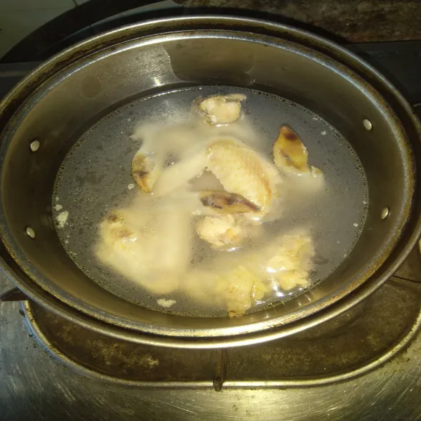 Rebus air dan masukkan ayam dengan api kecil dalam panci hingga ayam menjadi empuk mengeluarkan kaldu.