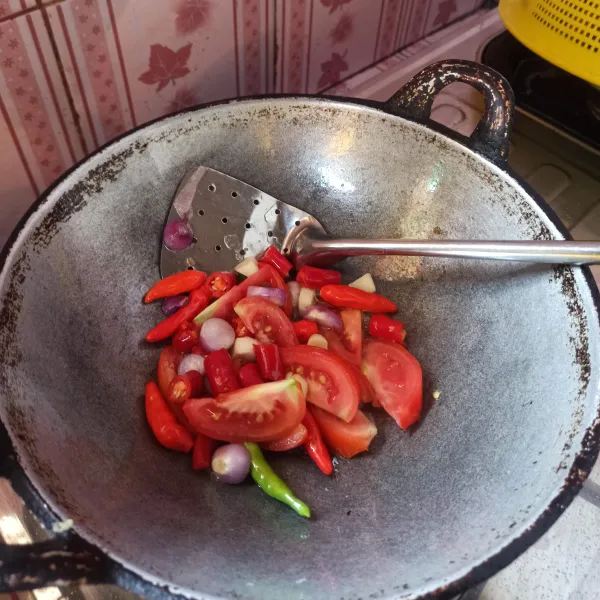 Selanjutnya goreng bawang putih, bawang merah, cabai dan tomat hingga layu.