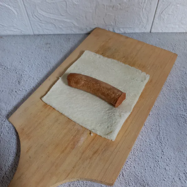 Letakkan sosis goreng di atas roti tawar.