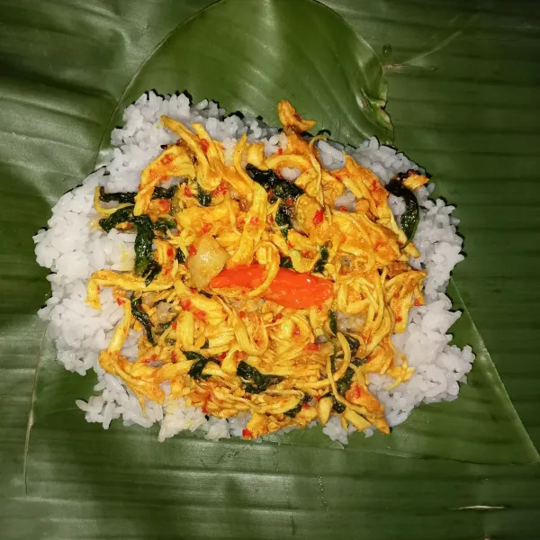 Tata daun pisang yang sudah di layukan dengan cara di panaskan di atas kompor dengan api kecil. Tata nasi di atas daun, kemudian tata ayam kemangi dan beri cabai rawit di atasnya. Lalu bungkus rapat dan sematkan dengan tusuk gigi sisi kanan dan kiri (lakukan hingga nasi dan lauk habis).