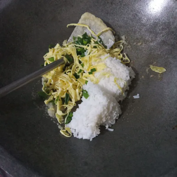 Lalu masukkan nasi, daun bawang, dan irisan telur dadar, kemudian aduk rata dengan bumbu.