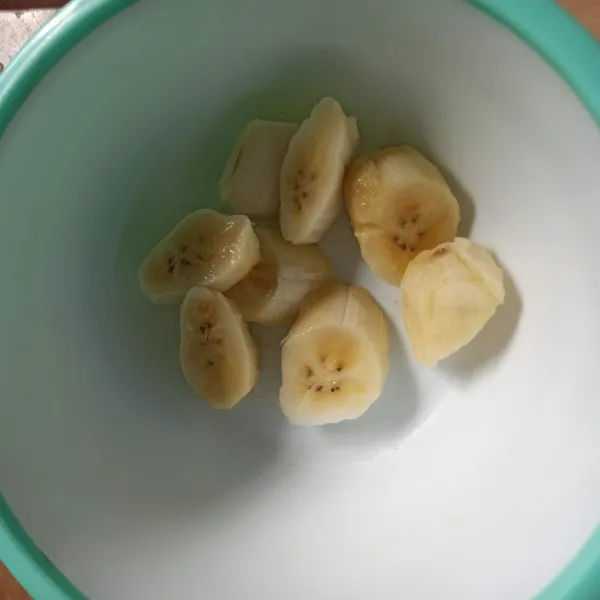 Kupas pisang, kemudian potong serong.