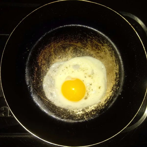 Panaskan sedikit minyak, buat telur sunny side atau telur mata sapi. Taburi dengan garam dan merica bubuk, lalu angkat.