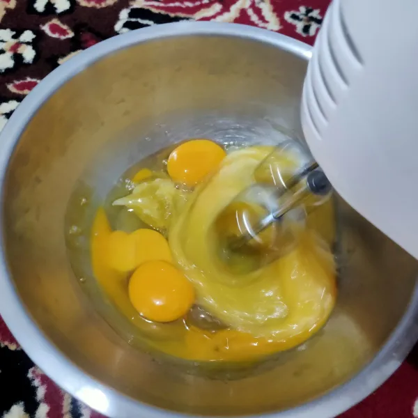 Mixer telur, gula pasir, vanilla cair, dan SP hingga mengembang putih berjejak.