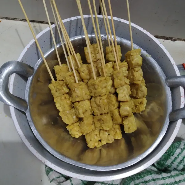 Tusuk tempe menggunakan tusuk sate.