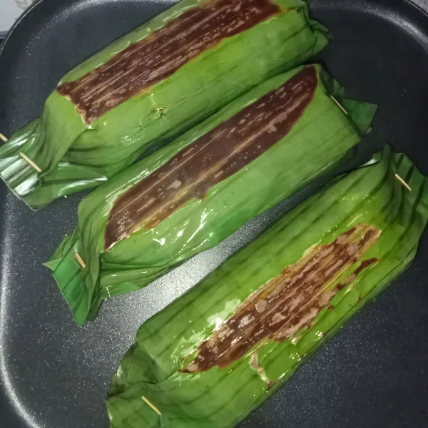 Panaskan teflon, bakar nasi di atas teflon hingga daun sedikit gosong. Kemudian sesekali olesi dengan minyak sedikit supaya warna daun mengkilat. Nasi bakar siap dinikmati dan selamat mencoba.