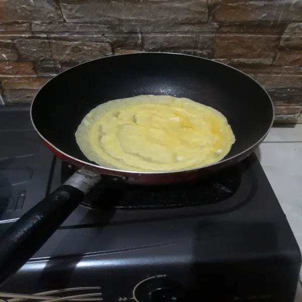 Olesi teflon dengan sedikit minyak, lalu buat 2 buah telur dadar tipis dan angkat.