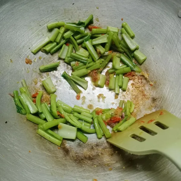 Masuklah batang sawi, aduk rata. Kemudian tuang air, masak sampai barang sawi setengah matang.