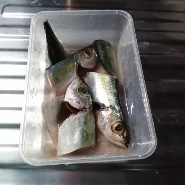 Cuci bersih ikan kemudian potong menjadi 2 bagian.