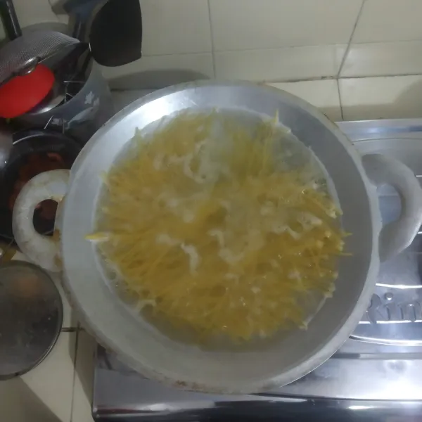 Panaskan air hingga mendidih, masukkan spaghetti dan minyak goreng agar tidak lengket, masak hingga Al dente.