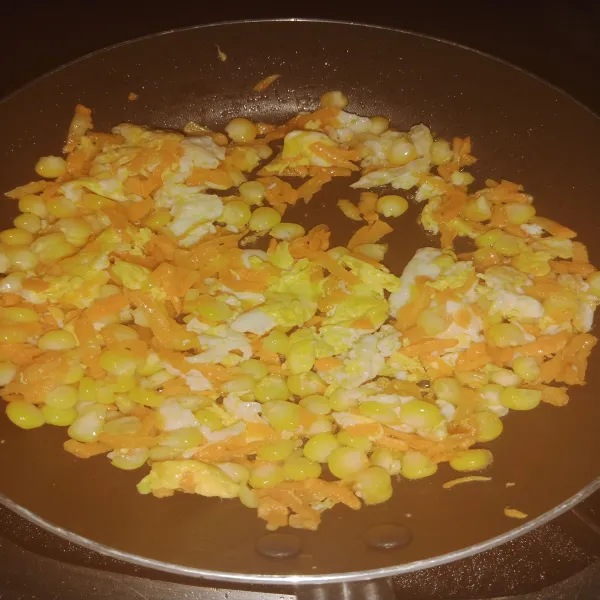 Masukkan jagung pipil dan wortel serut aduk rata.
