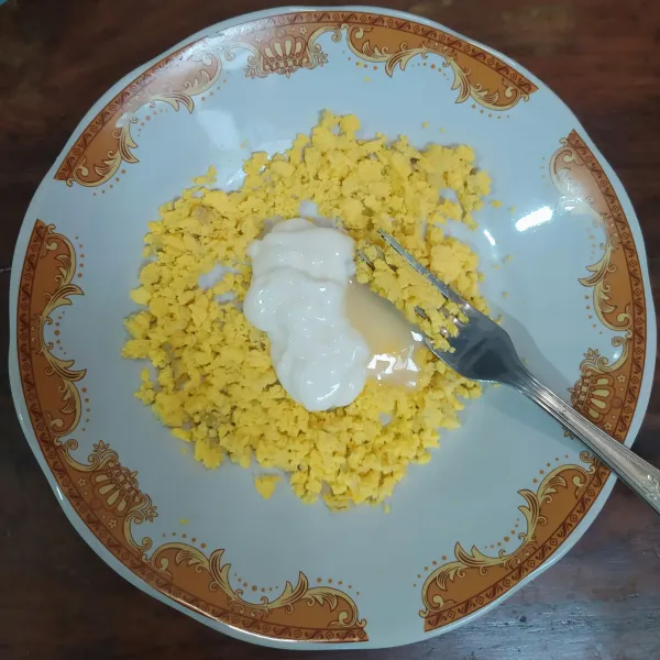 Haluskan kuning telur, masukkan mayonaise dan krimer kental manis, aduk rata.