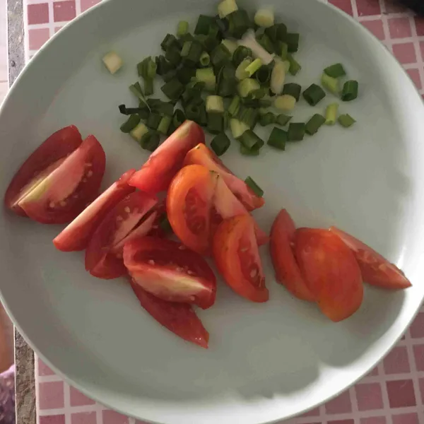 Potong-potong tomat dan daun bawang, sisihkan.