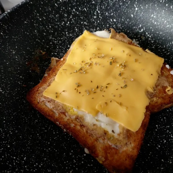 Balik roti, tambahkan cheese melt dan oregano diatas roti