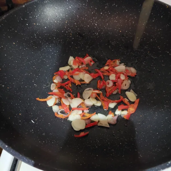 Tumis bawang merah dan bawang putih hingga harum, tambahkan cabe merah, aduk rata.