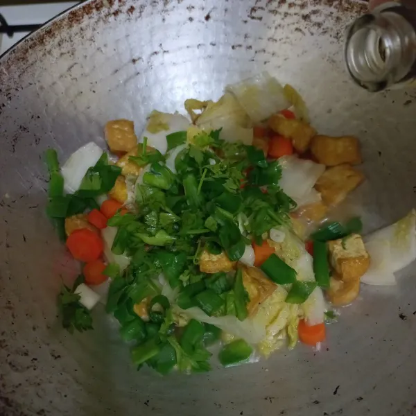 Tambahkan irisan bawang daun dan seledri masak hingga matang.