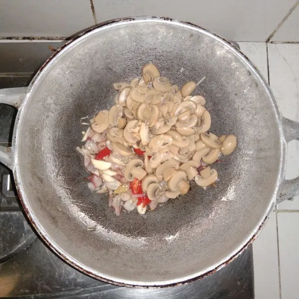 Masukkan jamur kancing, tumis hingga setengah matang.