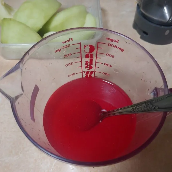 Di wadah terpisah, masukan minuman serbuk rasa strawberry lalu tuang air dan aduk hingga rata.