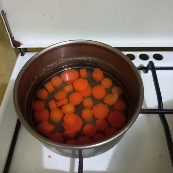Rebus irisan wortel hingga setengah matang, tiriskan.