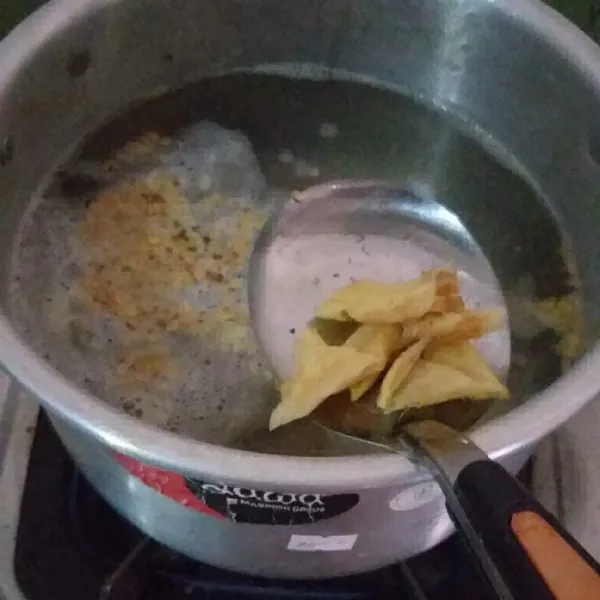 Masukan tumisan bawang putih, jahe, bumbu ke dalam rebusan daging.