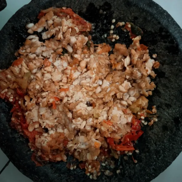 Tumbuk tempe goreng di atas sambal tadi, jangan terlalu halus.