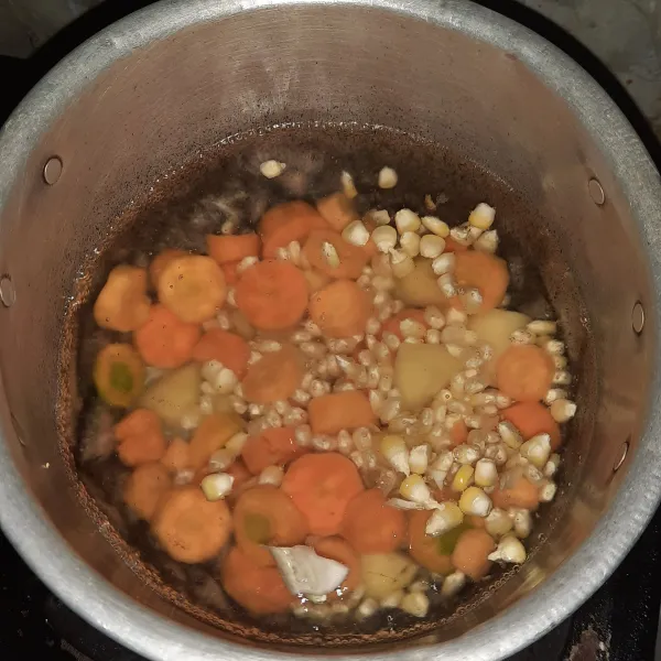 Masukan wortel, jagung, kentang, bawang putih yang ditelah dihaluskan. 
Masak sampai setengah matang.