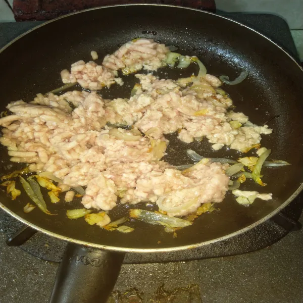 Masukkan daging ayam cincang. Aduk rata, masak sampai ayam berubah warna menjadi pucat.