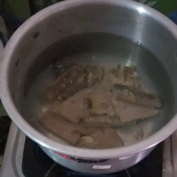 Pertama, cuci bersih daging. Lumuri dengan air perasan jeruk nipis, kemudian rebus hingga daging matang.