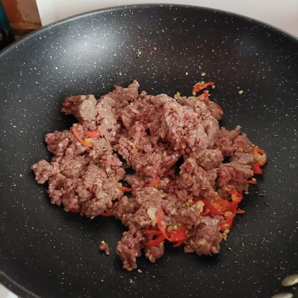 Masukkan daging cincang, masak hingga berubah warna.